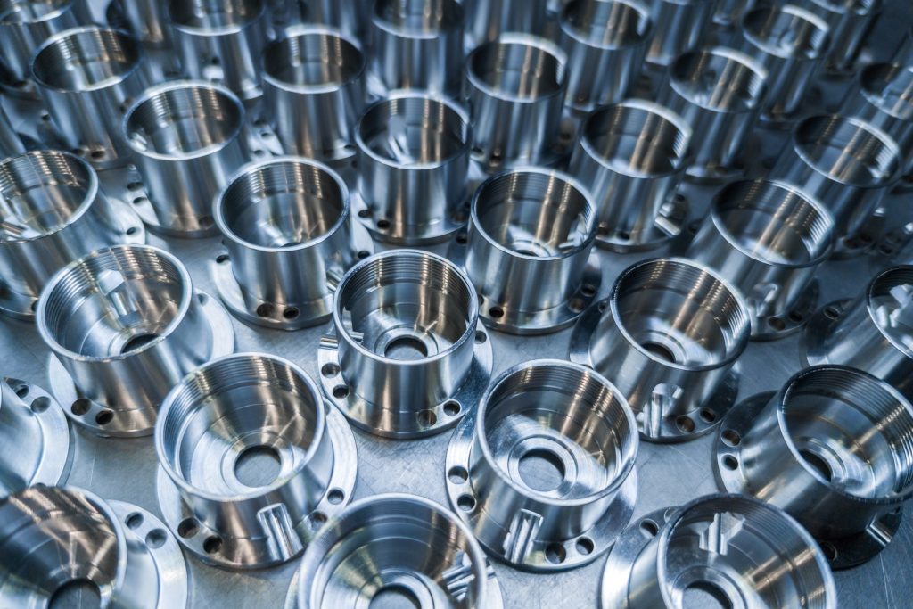 Abbildung mehrerer Metallteile aus dem Bereich CNC Drehen und Fräsen